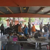 Neighbors and volunteers gathering beneath the pavilion