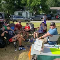 Community members resting and visiting near the outreach table