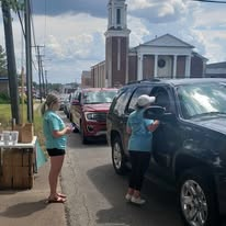 Volunteers sharing supplies with people in their vehicles