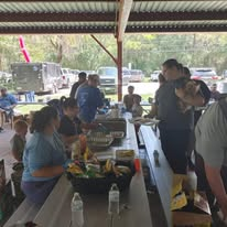 Volunteers sharing food and fellowship at a pavilion