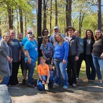 A community outreach team gathered among the trees