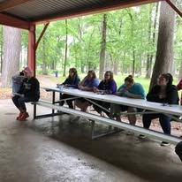 Community members seated together beneath the pavilion