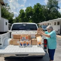 Volunteers unloading personal-care supplies from a pickup truck