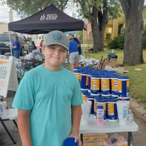 A young volunteer serving beside personal-care supplies